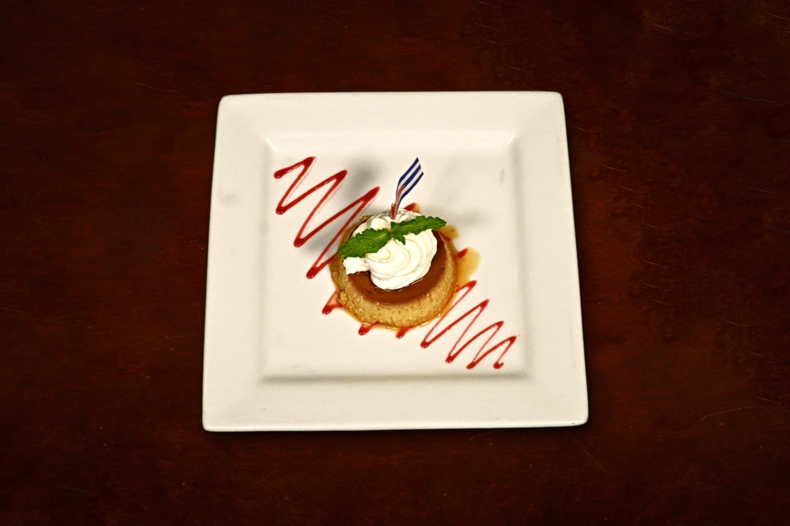 Flan: the Cuban classic, plated on a dark wood table